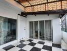 Covered patio with glass sliding door and checkered flooring