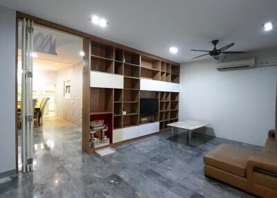 Modern living room with a sectional sofa, shelf, and TV