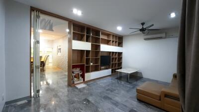 Modern living room with a sectional sofa, shelf, and TV