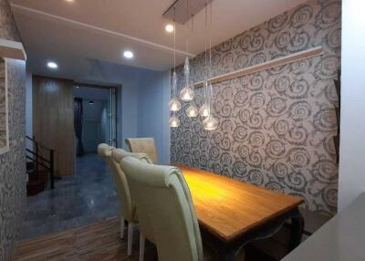 Well-lit dining area with elegant wallpaper and comfortable seating