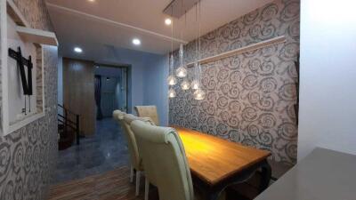 Well-lit dining area with elegant wallpaper and comfortable seating