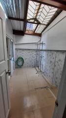 Clean and well-lit utility room with tiled walls and ample space