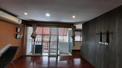 Modern living area with wooden flooring and glass doors