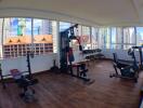 Modern gym with various fitness equipment and city view