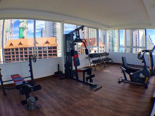 Modern gym with various fitness equipment and city view