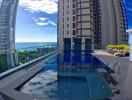 Rooftop swimming pool with a view of the ocean and nearby buildings