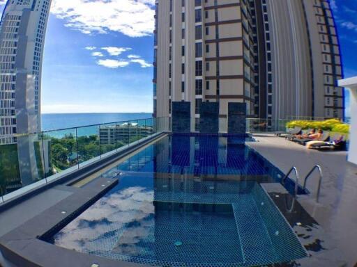 Rooftop swimming pool with a view of the ocean and nearby buildings