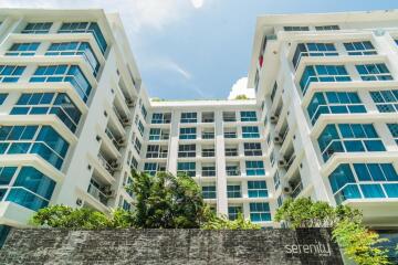 Modern apartment building exterior with large windows and greenery