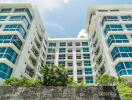 Modern apartment building exterior with large windows and greenery