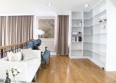 Spacious and bright living room with wooden flooring and built-in shelves