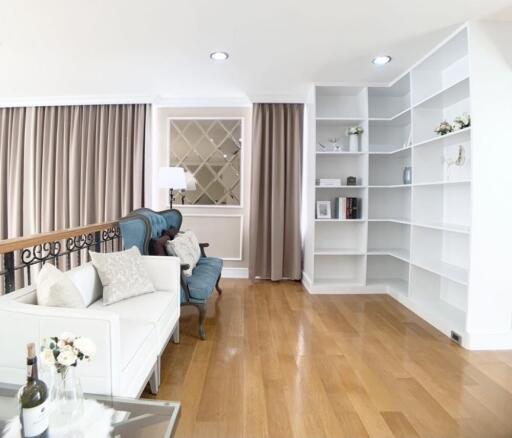 Spacious and bright living room with wooden flooring and built-in shelves