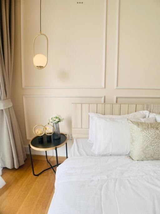 Well-lit bedroom with bed, nightstand, and decor