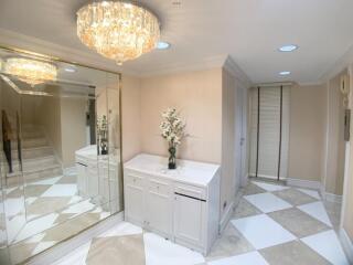 Well-lit and modern hallway with chandelier and mirror