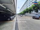 Covered parking area beside a building with several parked cars