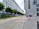 Exterior view of a modern apartment building with pathway and greenery