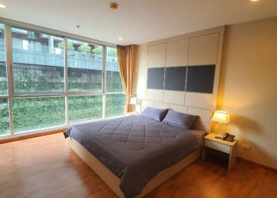 Spacious bedroom with large windows and wooden floor