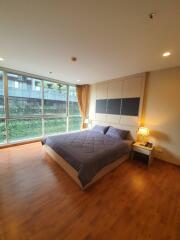 Spacious bedroom with large windows and wooden floor