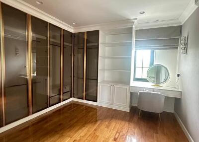 Bedroom with wooden flooring, built-in wardrobe, and vanity area