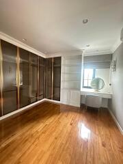 Bedroom with wooden flooring, built-in wardrobe, and vanity area