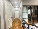 Spacious hallway with natural wood flooring and iron railing