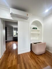 Main living space with hardwood floors and built-in shelves