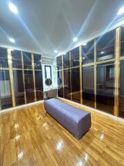 Spacious walk-in closet with wooden flooring and ample lighting