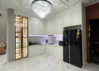 Modern kitchen with chandelier and white cabinetry