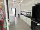 Modern kitchen with sleek white cabinetry and black appliances