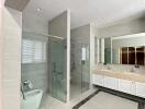 Spacious modern bathroom with glass shower and double sink vanity