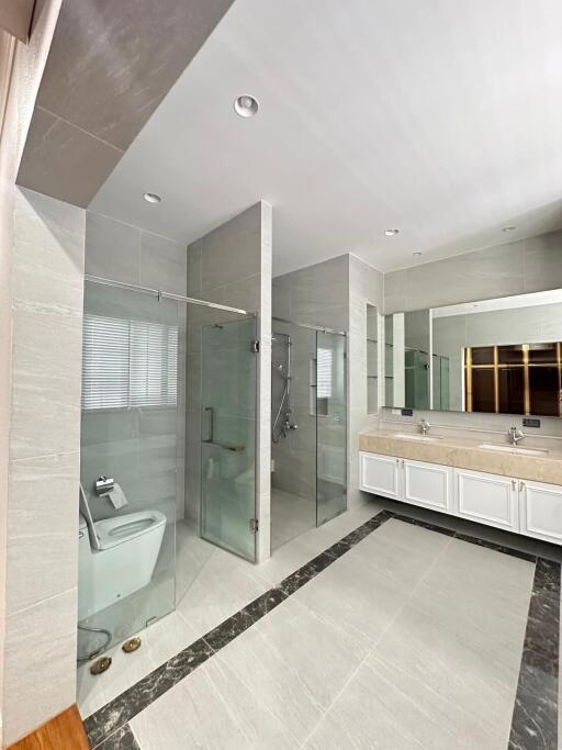 Spacious modern bathroom with glass shower and double sink vanity