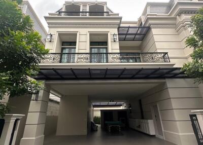 Front view of a multi-story house with carport and balcony