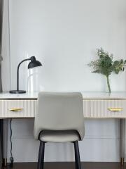 Modern home office with desk, chair, and decorative plant