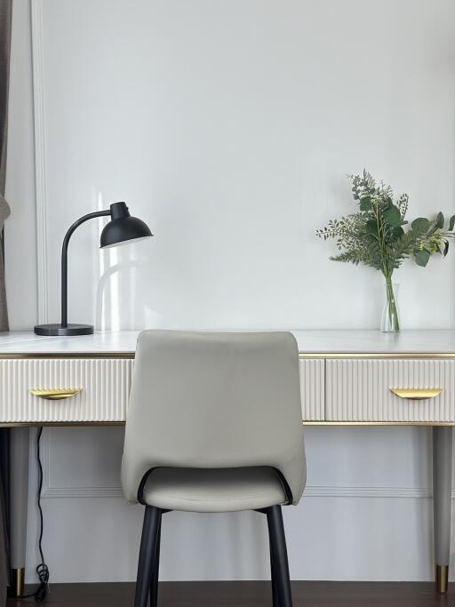 Modern home office with desk, chair, and decorative plant