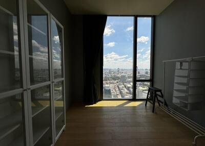 Room with wooden floor, glass cabinets, and a large window with city view