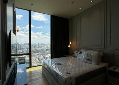 Modern bedroom with floor-to-ceiling windows and a city view