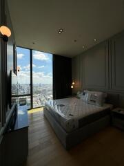 Modern bedroom with floor-to-ceiling windows and a city view