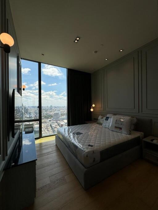 Modern bedroom with floor-to-ceiling windows and a city view