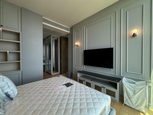 Modern bedroom with wall-mounted TV and built-in storage