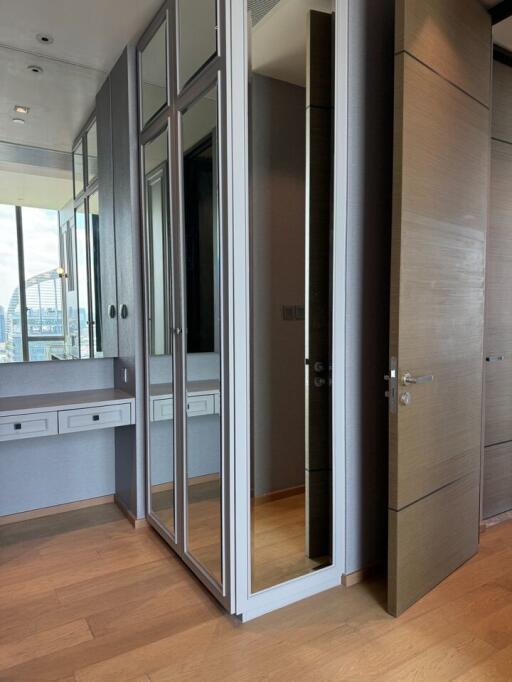 Modern bedroom with large mirror and built-in wardrobe