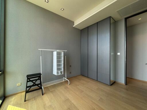 Minimalist bedroom with wooden flooring and wardrobe