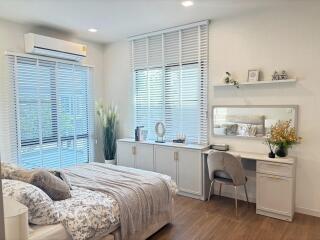 Bright and modern bedroom with a desk and large windows