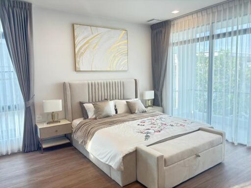 Spacious and modern bedroom with large windows, elegant bed, and tasteful decor