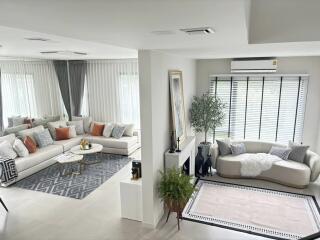 Spacious and modern living room with large windows and elegant decor