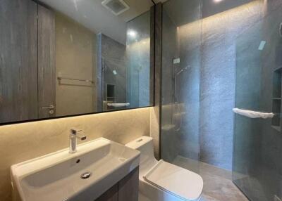 Modern bathroom with sink, toilet, and glass-enclosed shower