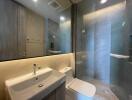 Modern bathroom with sink, toilet, and glass-enclosed shower