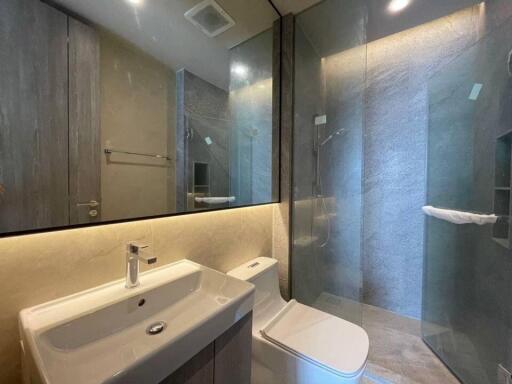 Modern bathroom with sink, toilet, and glass-enclosed shower