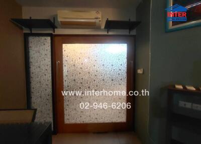 Living room with air conditioner and decorative glass door