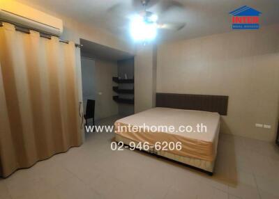 Bedroom with bed, curtains, air conditioning, and a chair