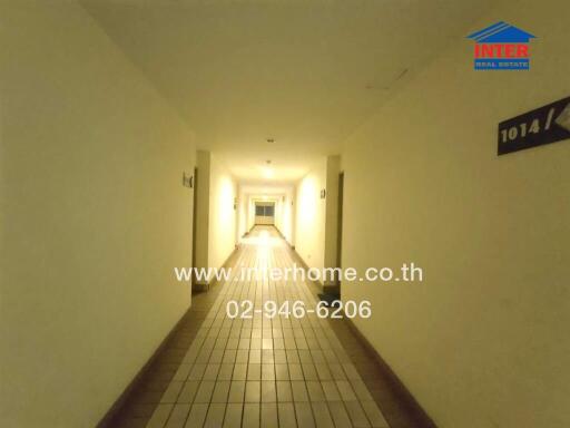 Hallway with tiled floor and door numbers on the walls