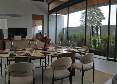 Modern dining area with glass walls and pool view